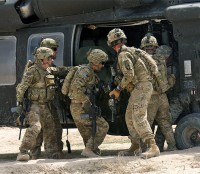 Pathfinders from Task Force Palehorse, which is part of the 159th Combat Aviation Brigade (Task Force Thunder), pull a large bag containing humanitarian assistance supplies out of a UH60M Black Hawk helicopter in Deh Gholaman village in southern Afghanistan, March 18th. The supplies were donated by individuals and companies in the U.S. (Photo by Sgt. 1st Class Stephanie Carl)