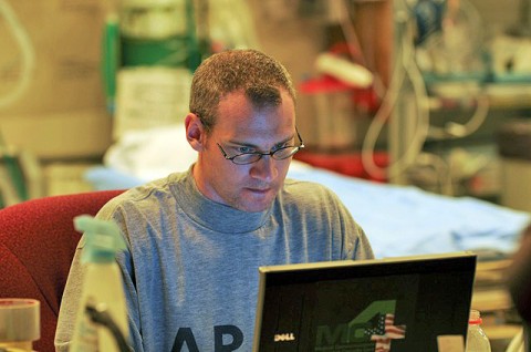 U.S. Army Maj. Mike Kilbourne of Richmond Hill, GA, surgeon for the 102nd Forward Surgical Team at Forward Operating Base Wright, enters medical information, April 2nd, about U.S. Army Staff Sgt. Daniel Hayes of Grand Rapids, MI, after treating Hayes for a gunshot wound to the face and chest. (Photo by U.S. Air Force Capt. Peter Shinn, 734th Agribusiness Development Team)