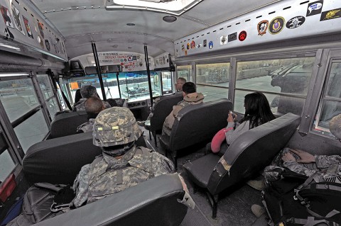 Passengers wait aboard a bus for a driver from the 455th Expeditionary Aerial Port Squadron's passenger terminal to take them to their flight from Bagram Airfield, Afghanistan. Recently, the squadron broke their-own record of 50,748 passengers moved in one day set January 2011. Last month, due mainly to the rotation of the Army's 101st Airborne Division with 1st Cavalry from Fort Hood, TX, Bagram 2T2X1s moved 59,327 passengers in and out of the country. (U.S. Air Force photo by Senior Airman Sheila deVera)