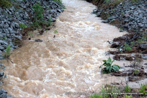 Rushing water heading into a culvert.