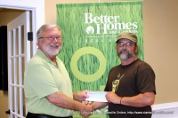 Maurice Vaughn of Better Homes and Garden Real Estate Hometown Connection presents a donation to Kenny York of Mana Café Ministries