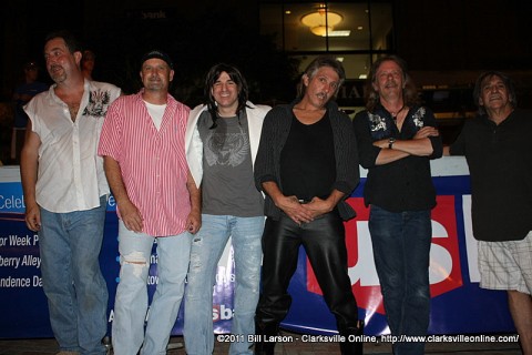 The members of Chain Reaction pose for a photograph with fan Phil Lewis (center)