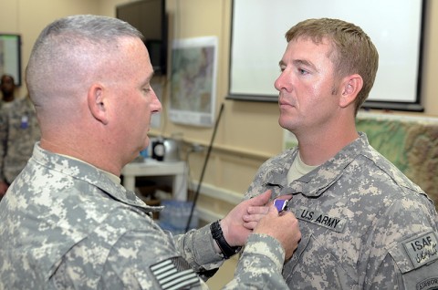 101st Sustainment Brigade Commander Col. Michael Peterman awards Maj. Mike Cupp the Purple Heart for wounds received during the suicide bombing at Forward Operating Base Gamberi April 16th. (Photo by Spc. Michael Vanpool)