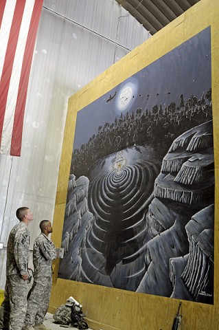 Sgt. 1st Class Narada Johnson and Spc. Blake Chambers, 101st Sustainment Brigade, look on at the 14 foot mural recently completed in the Rigger Shed at Bagram Air Field. (Photo by Spc. Michael Vanpool)