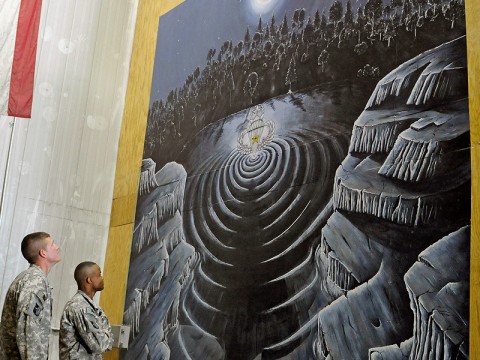 Sgt. 1st Class Narada Johnson and Spc. Blake Chambers, of the 11th Quartermaster Detachment, 101st Special Troops Battalion, 101st Sustainment Brigade, look on at the 14 foot mural recently completed in the Rigger Shed at Bagram Air Field. Chambers completed the mural in his spare time, adding distinctions of the unique job of a U.S. Army Rigger. (Photo by Spc. Michael Vanpool)