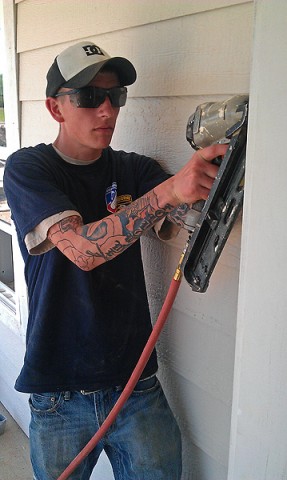 U.S. Army Pvt. Tanner Money from Beaumont, TX, attaches door trim May 8th. Money participated in a Mother's Day Habitat for Humanity home build, helping finish the exteriors of four homes on Ewing Drive in Nashville, TN.  (U.S. Army Courtsey Photo)