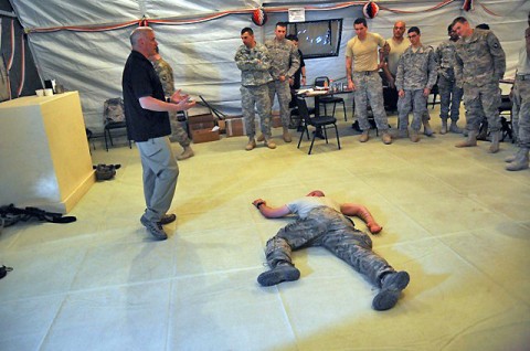 Tim Webb, an instructor for Northern Cairn, is going over the different ways you can secure and roll over a injured Soldier without compromising the spinal cord during the Wilderness Medicine class held at the Currahee Café on Forward Operating Base Sharana, Afghanistan, May 14th, while the class of Task Force Currahee medics observe. (Photo by U.S. Army Staff Sgt. Todd Christopherson, Task Force Currahee Public Affairs)