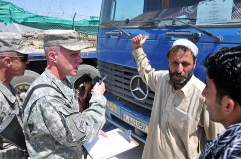 Sgt. Dennis Stanley and Staff Sgt. Blake Adams, both of the 101st Sustainment Brigade anti-corruption interview team, talks with a local trucker about the conditions on the road. The team was created to focus on corruption issues host nation truckers face on the road. (Photo by Sgt. 1st Class Peter Mayes)