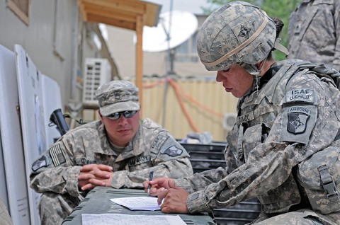 Spc. Jessica Tosado, a competitor in the 101st Special Troops Battalion, 101st Sustainment Brigade soldier and non-commissioned officer of the quarter competition of Alpha Company, identifies terrain features on a map as her sponsor, Staff Sgt. Chad Cooper, looks on. (Photo by Spc. Michael Vanpool)