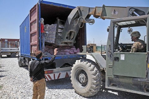 Staff Sgt. William Lyons of the 584th Supply Maintenance Company, 142nd Combat Sustainment Support Battalion, 101st Sustainment Brigade, loads bags of flour into the back of a truck Bagram Humanitarian Yard. The battalion recently sent more than 600,000 pounds of supplies to a local village of Sar-E Pol, which was suffering from a drought. (Photo by Sgt. 1st Class Peter Mayes)