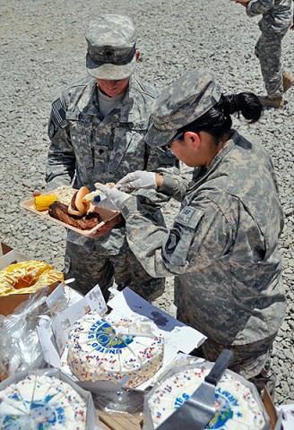 U.S. Army Pfc. Lydia Johnson, with 4th Brigade Combat Team, 101st Airborne Division, Task Force Currahee, serves U.S. Army Spc. Richard Hon, personal security detail specialist with TF Currahee, a slice of Army birthday cake during a barbecue celebrating the United States Army’s 236th birthday June 14th. (Photo by U.S. Army Sgt. Christina Sinders, Task Force Currahee Public Affairs)