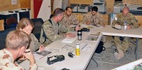 Pilots from Australian, United Arab Emirates and U.S. army aviation task forces review and discuss plans before a combined mission June 30th to destroy insurgent repeater towers in southern Afghanistan. (Photo by Spc. Mario Smith)