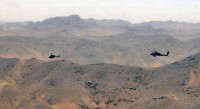 Pilots from United Arab Emirates Army Aviation Task Force 14, in their UH-64D Apache Longbow helicopter (right), and Task Force Thunder, 159th Combat Aviation Brigade, 101st Airborne Division, in their OH-58D Kiowa Warrior helicopter, search for insurgent repeater towers during a combined mission June 28th in southern Afghanistan. (Photo by Spc. Jennifer Andersson)