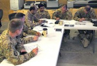 Pilots from United Arab Emirates Army Aviation Task Force 14 and Task Force Thunder, 159th Combat Aviation Brigade, 101st Airborne Division, review the plan of action before a combined mission June 28th to destroy insurgent repeater towers in southern Afghanistan. (Photo by Spc. Jennifer Andersson)