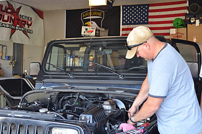 Staff Sgt. Jason Axelson, Operations NCO at the Installation Chaplain’s office, deconstructs a 1995 Jeep Wrangler YJ at his Clarksville home, July 9th. The vehicle was originally purchased by Sgt. 1st Class Charles Adkins, an 101st Sustainment Brigade Soldier, to complete as a father-son project upon his return from Afghanistan. After Adkins was killed in action, Axelson decided to complete the project in honor of the fallen Soldier and his Family. (Megan Locke, Fort Campbell Courier)