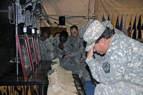 Soldiers with the 131st Transportation Company, 142nd Combat Sustainment Support Battalion, 101st Sustainment Brigade, pay their final respects to three of their fallen comrades who were killed when their convoy struck an Improvised Explosive Device July 18th. (Photo by Cpl. Sarah Keegan)