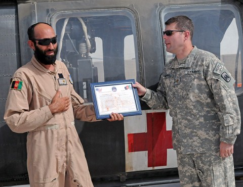 Afghan Air Force flight medic Sgt. Gulap Ahmadzia receives a certificate of completion, July 27th, from Company C, 1st Battalion, 52nd Aviation Regiment company commander Maj. Michael Mendenhall, for completion of the U.S. Army and Afghanistan Air Force medical evacuation partnership program here. Ahmadzia is the first Afghan flight medic to join Task Force Thunder's medevac crews as they move patients off of the battlefield. (Photo by Sgt. Shanika Futrell)