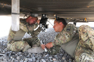 Spc. David Rydel (right) of Inver Grove Heights, MN, hands a wrench to Spc. Kenneth Jones of Nelson, MO, as they attach a part to a CH-47D Chinook helicopter here July 23rd. Both Soldiers are maintainers for Company B, 1st Battalion, 52nd Aviation Regiment, which is a new asset to Task Force Thunder. (Photo by Jennifer Andersson, 159th Combat Aviation Brigade).