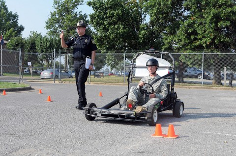 Police Lt. Raymond Lepper, a provost martial with the Directorate of Emergency Services, walks with Spc. Ian Murphy, a rifleman with Company B, 1st Battalion, 327th Infantry Regiment, 101st Airborne Division, as he gets a feel for the Simulated Impaired Driving Experience course here, Sept. 1. The SIDNE provided unique training to soldiers during Safety Stand-down Day to simulated driving under the influence while the driver was still sober. (Photo by Spc. Richard Daniels Jr.) Police Lt. Raymond Lepper, a provost martial with the Directorate of Emergency Services, walks with Spc. Ian Murphy, a rifleman with Company B, 1st Battalion, 327th Infantry Regiment, 101st Airborne Division, as he gets a feel for the Simulated Impaired Driving Experience course here, Sept. 1. The SIDNE provided unique training to soldiers during Safety Stand-down Day to simulated driving under the influence while the driver was still sober. (Photo by Spc. Richard Daniels Jr.)