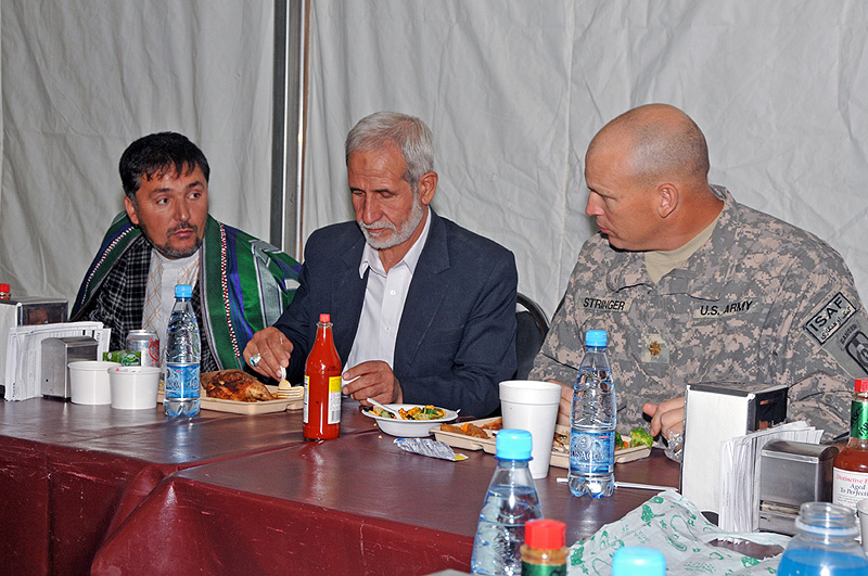 Deh Dadi District Deputy Subgovernor Mohammad Akbar Askari (center) enjoys his lunch with Maj. John Stringer (right), executive officer for the 530th Combat Sustainment Support Battalion, 101st Sustainment Brigade, at the base dining facility. The battalion commander’s emergency response program team hosted Askari and other village elders while also discussing future development projects for the district. (Photo by Sgt. 1st Class Peter Mayes)