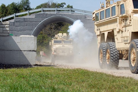 Civilians participating in the Joint Civilian Orientation Conference sponsored by the Secretary of Defense ride in a convoy during their visit to Fort Campbell, September 22nd. The visible smoke is from an improvised explosive device simulator that was detonated on the convoy to give the JCOC participants a small taste of what it's like to be hit by an IED. (Photo by Sgt. Scott Davis)