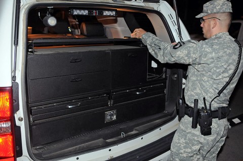 Staff Sgt. Robert J. Streit, patrol supervisor from Headquarters and Headquarters Company, 1st Special Troops Battalion, 1st Brigade Combat Team, secures the equipment lock boxes located in the back of his vehicle Oct. 17th outside the post police station during his vehicle inspection before heading out on patrol. (Photo by Sgt. Jon Heinrich)