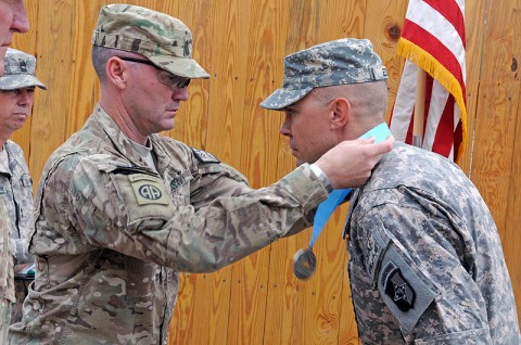 Staff Sgt. Danny Estep, Alpha Company, 101st Special Troops Battalion, 101st Sustainment Brigade, receives his Sgt. Audie Murphy Club Medal during an induction ceremony at Bagram Air Field, Afghanistan, from Command Sgt. Maj. Travis Williams, command sergeant major, Joint Sustainment Command-Afghanistan. Estep was one of four new inductees into the prestigious organization. (Photo by Spc. Michael Vanpool)