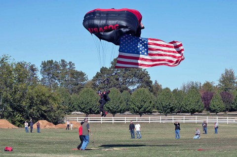 A Black Dagger from the U.S. Army Special Operations Command parachute demonstration team delivers the American flag as the National Anthem plays to begin the 160th Special Operations Aviation Regiment 30th Anniversary Celebration on Oct. 15, 2011. (160th Special Operations Aviation Regiment photo)