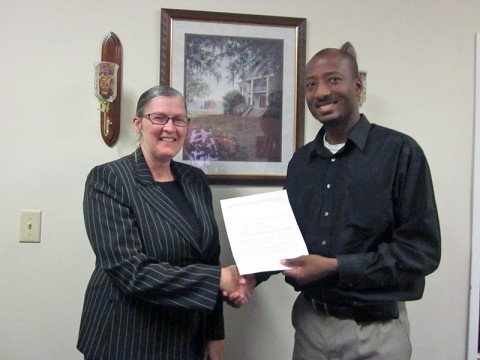 Gladyn Minzey receives the LEAP Organization scholarship from Richard Garrett.