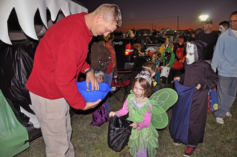 1st Lt. Daniel Collini of Company A, 2nd Brigade Special Troops Battalion, 2nd Brigade Combat Team, 101st Airborne Division (Air Assault), hands out candy to the Strike family members dressed in costumes during the battalion’s Trunk or Treat event held at Strike, October 21st. 