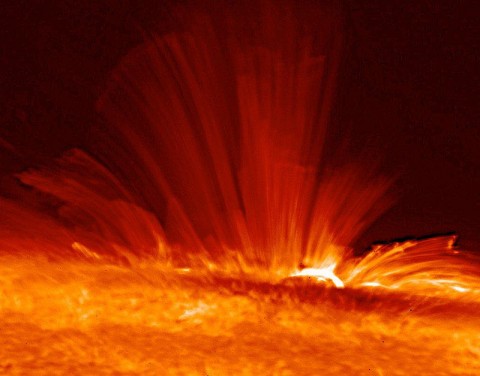 Vivid orange streamers of super-hot, electrically charged gas (plasma) arc from the surface of the Sun, revealing the structure of the solar magnetic field rising vertically from a sunspot. This extremely detailed image of the Sun was taken by Hinode's Solar Optical Telescope on November 20th, 2006 and showed that the Sun’s magnetic field was much more turbulent and dynamic than previously known. (Credit: Hinode, JAXA/NASA)