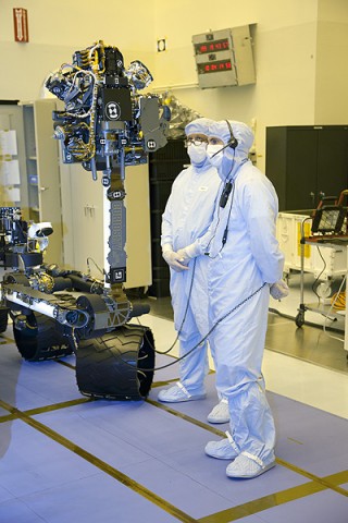 Technicians examine the turret of scientific instruments at the end of the MSL's arm. The turret weighs 73 pounds and holds the machines that will touch the rocks and soil on Mars to gather information. (Photo credit: NASA/Frankie Martin)