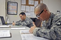 Spc. Michael Lombardo, a medic with Headquarters and Headquarters Company, 1st Special Troops Battalion, 1st Brigade Combat Team, 101st Airborne Division, and Sgt. Adam Hawes, a team leader with HHC, 1st STB, check their logs and regulations while on staff duty November 10th. (Photo by Sgt. Richard Daniels Jr.)