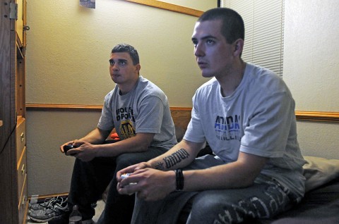 (Left) Spc. Jeremy Sweeting, an assistant gunner with Company B, 2nd Battalion, 327th Infantry Regiment, 1st Brigade Combat Team, and Spc. Sean Russell, a M240 machine gunner, play together on a recently released first-person shooter here at the 1st Brigade barracks Nov. 21st. (Photo by Sgt. Richard Daniels Jr.)