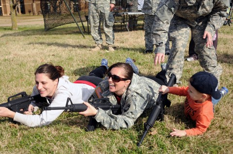 Two of the spouses of 1st Squadron, 32nd Cavalry, 1st Brigade Combat Team, receive a “little” help in pulling security during the Spouses’ Spur Ride Nov. 19th outside the squadron headquarters here. (Photo by Sgt. Jon Heinrich)