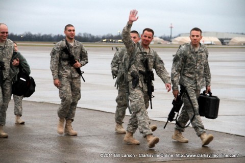 A returning soldier waves at his family