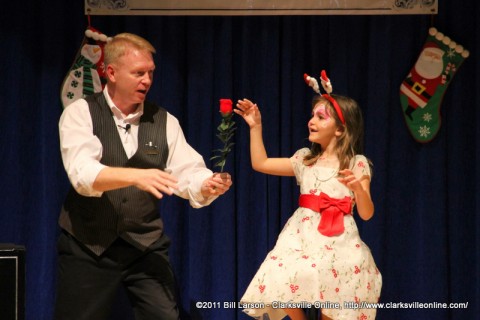 Magician Russ Nowack astounds a young girl with one of his magic tricks