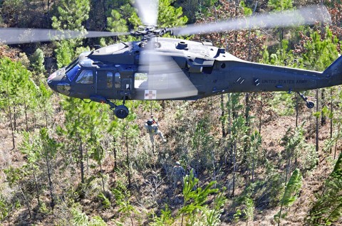 A flight medic of 6th Battalion, 101st Combat Aviation Brigade, lowers himself to the ground by a hoist mechanism installed on the UH-60A Black Hawk medevac helicopter to retrieve a medical patient of the 1st Battalion, 82nd Infantry Regiment, during a situational training exercise at the Joint Readiness Training Center at Fort Polk, LA, Jan. 17th, 2012. The 101st CAB is training at JRTC throughout the month of January. (Photo by Sgt. Tracy Weeden)