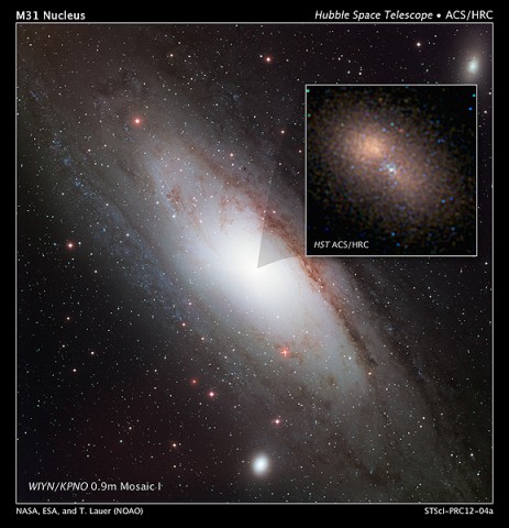 This is a Hubble image of the 100-million-solar-mass black hole at the hub of the neighboring spiral galaxy M31, or the Andromeda galaxy. The compact cluster of blue stars is surrounded by the larger “double nucleus” of M31. The double nucleus is actually an elliptical ring of old reddish stars in orbit around the black hole but more distant than the blue stars. (Credit: NASA, ESA, and T. Lauer (National Optical Astronomy Observatory))