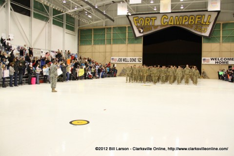 The soldiers march into the hanger as their families cheer loudly for them The soldiers march into the hanger as their families cheer loudly for them