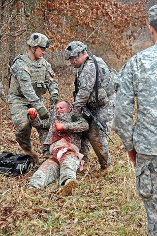 Spc. Aaron McCosh and Sgt. Juan Gonzalez carry a wounded Soldier to a medical litter during a stress shoot training exercise at Fort Campbell’s Range 40a, Feb. 16th. (U.S. Army photo by Sgt. Joe Padula, 2nd BCT PAO, 101st Abn. Div.)