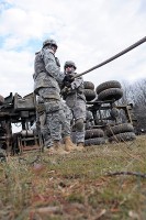 Soldiers of Company B, 426th Brigade Support Battalion, 1st Brigade Combat Team, 101st Airborne Division, help tighten the chains to role the incapacitated vehicle back up right here at the ranges Jan. 31st. (Photo by Sgt. Richard Daniels Jr.)