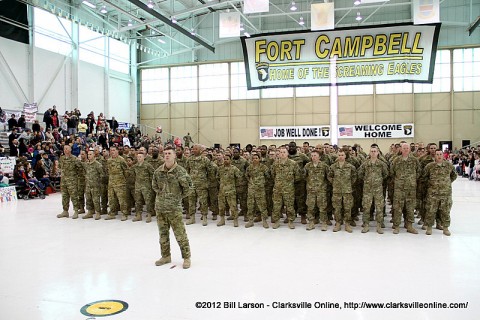 The returning soldiers proudly stand before their families and friends