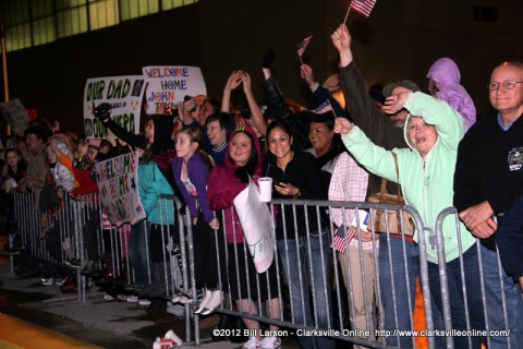 Family members cheer as their soldier passes by