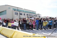 The families cheering as the returning soldiers start to exit the aircraft