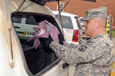 Spc. Ignacio Rivera, an assistant patrol supervisor with the 551 Military Police Company, 716th MP Battalion, 101st Sustainment Brigade, places a handmade blanket in his patrol vehicle. Blankets are being included in the patrol kit bags as part of “Operation Linus,” a mission to give comfort and security to children in stressful situation. (Photo by Spc. Michael Vanpool)