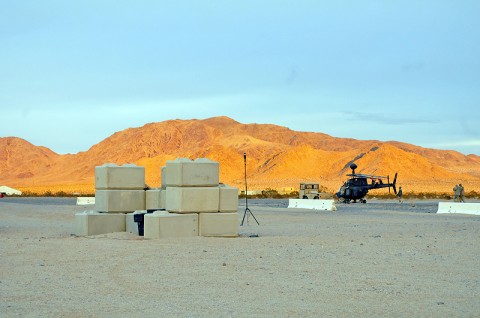 The Kiowa Warrior helicopter crews of Task Force Saber, 101st Combat Aviation Brigade escort their aircraft back out to the flight line after a violent wind hit Forward Operating Base Miami at the National Training Center here Feb. 16th, 2012. (Photo by Sgt. Tracy Weeden)