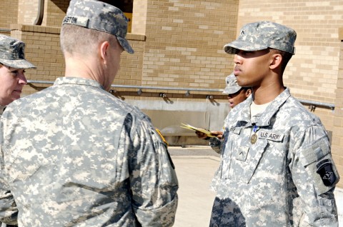 Pvt. Terrance Bob (right), a cargo specialist with the 372nd Inland Cargo Transfer Company, 129th Combat Sustainment Support Battalion, 101st Sustainment Brigade, stands in front a formation of the 129th CSSB as they applaud what he did on Dec. 8th, 2011. Bob received an Army Achievement Medal for his actions. (U.S. Army/Spc. Michael Vanpool)