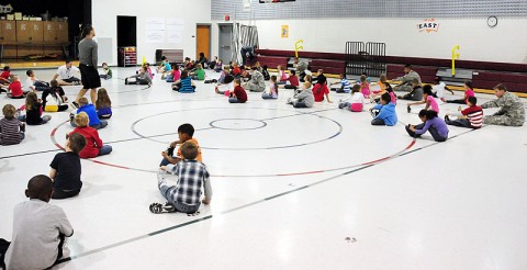 Soldiers from 4th Battalion, 320th Field Artillery Regiment, 4th Brigade Combat Team, 101st Airborne Division, do stretching exercises in physical education alongside elementary school students, April 24th, 2012, during their visit to West Creek Elementary School in Clarksville, Tennessee. (Photo by Sgt. Kimberly Menzies)