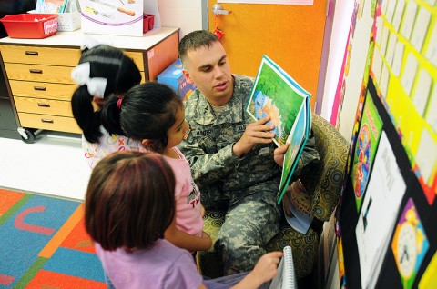 U.S. Army Spc. Kyle M. Hunter, the chaplain’s assistant from Headquarters and Headquarters Battery, 4th Battalion, 320th Field Artillery Regiment, 4th Brigade Combat Team, 101st Airborne Division, and native of Deland, Fla., reads a story to several first-graders, April 24th, 2012, during his visit to West Creek Elementary School in Clarksville, Tennessee. (Photo by Sgt. Kimberly Menzies)